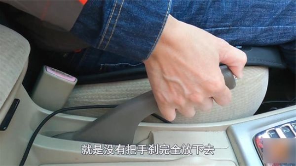 车启动手刹是放下还是抬起来